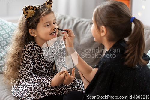 Image of girls doing face painting on halloween at home