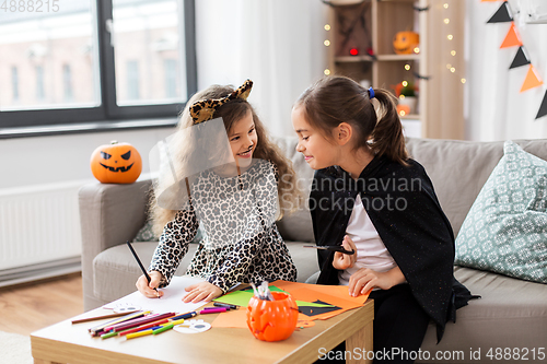 Image of girls in halloween costumes doing crafts at home