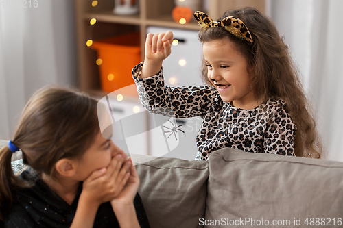 Image of girls in halloween costumes playing with spider