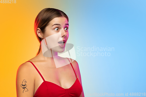 Image of Caucasian young woman\'s portrait on gradient studio background in neon
