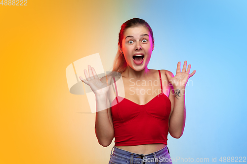 Image of Caucasian young woman\'s portrait on gradient studio background in neon