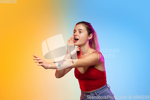 Image of Caucasian young woman\'s portrait on gradient studio background in neon
