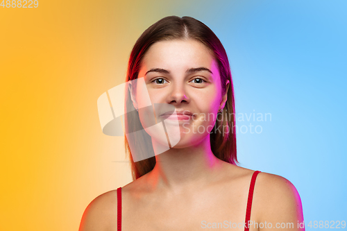 Image of Caucasian young woman\'s portrait on gradient studio background in neon