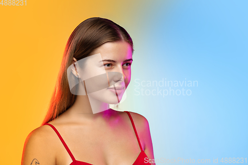 Image of Caucasian young woman\'s portrait on gradient studio background in neon