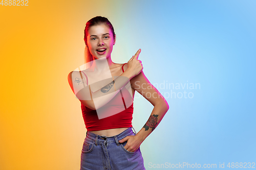 Image of Caucasian young woman\'s portrait on gradient studio background in neon