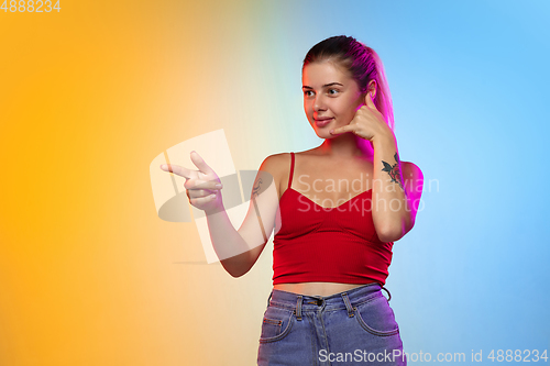 Image of Caucasian young woman\'s portrait on gradient studio background in neon