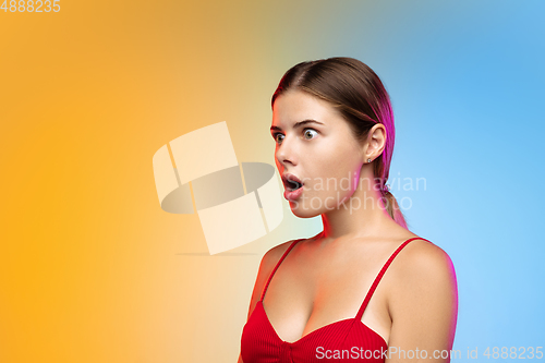 Image of Caucasian young woman\'s portrait on gradient studio background in neon