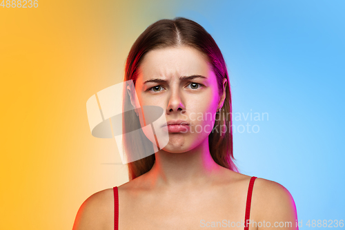 Image of Caucasian young woman\'s portrait on gradient studio background in neon