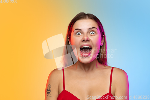 Image of Caucasian young woman\'s portrait on gradient studio background in neon