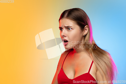 Image of Caucasian young woman\'s portrait on gradient studio background in neon