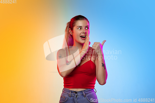 Image of Caucasian young woman\'s portrait on gradient studio background in neon