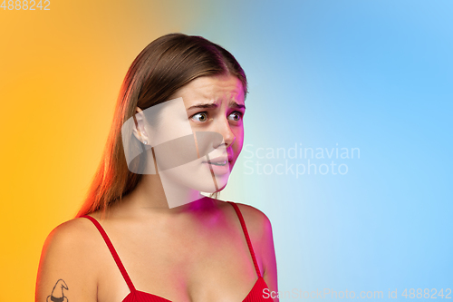 Image of Caucasian young woman\'s portrait on gradient studio background in neon