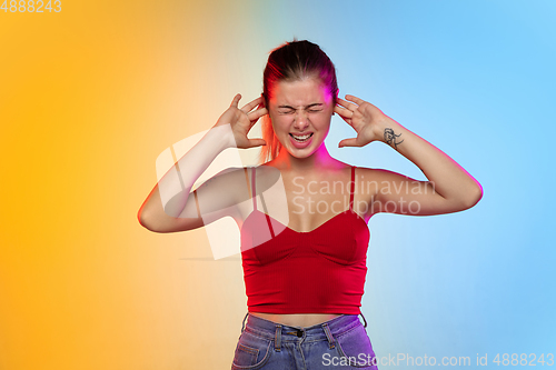 Image of Caucasian young woman\'s portrait on gradient studio background in neon