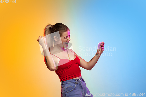Image of Caucasian young woman\'s portrait on gradient studio background in neon