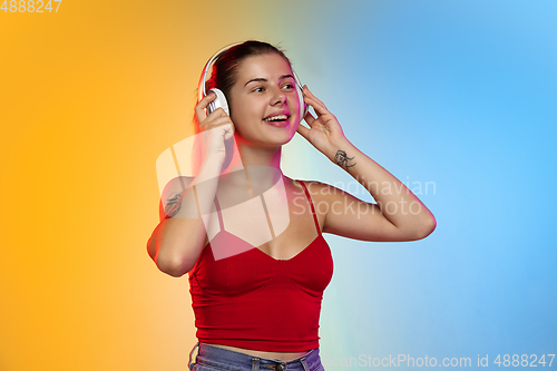 Image of Caucasian young woman\'s portrait on gradient studio background in neon