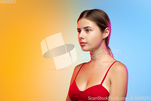 Image of Caucasian young woman\'s portrait on gradient studio background in neon