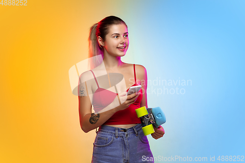 Image of Caucasian young woman\'s portrait on gradient studio background in neon