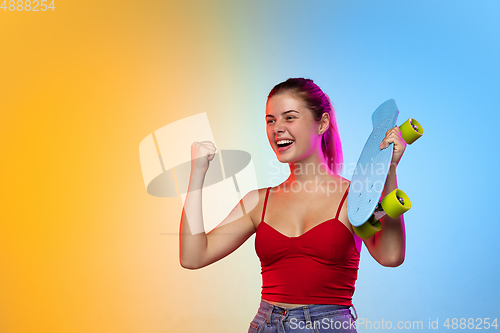 Image of Caucasian young woman\'s portrait on gradient studio background in neon