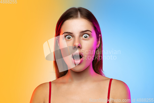 Image of Caucasian young woman\'s portrait on gradient studio background in neon
