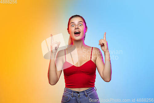 Image of Caucasian young woman\'s portrait on gradient studio background in neon