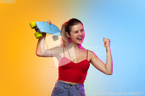 Image of Caucasian young woman\'s portrait on gradient studio background in neon
