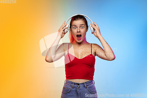 Image of Caucasian young woman\'s portrait on gradient studio background in neon