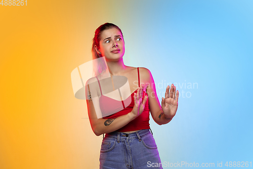 Image of Caucasian young woman\'s portrait on gradient studio background in neon