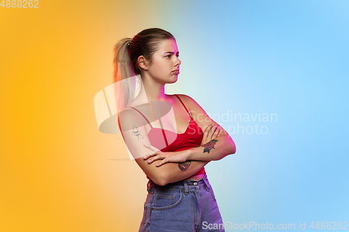 Image of Caucasian young woman\'s portrait on gradient studio background in neon