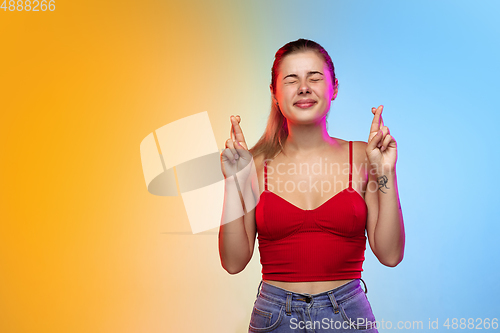 Image of Caucasian young woman\'s portrait on gradient studio background in neon