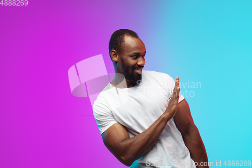 Image of African-american young man\'s portrait on gradient studio background in neon