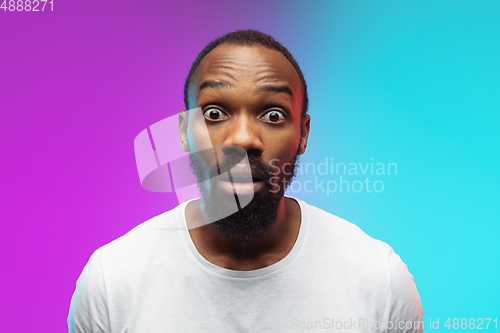 Image of African-american young man\'s portrait on gradient studio background in neon, close up