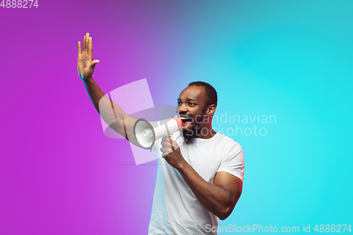 Image of African-american young man\'s portrait on gradient studio background in neon