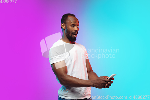Image of African-american young man\'s portrait on gradient studio background in neon