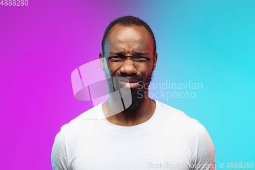 Image of African-american young man\'s portrait on gradient studio background in neon, close up