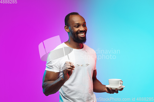 Image of African-american young man\'s portrait on gradient studio background in neon
