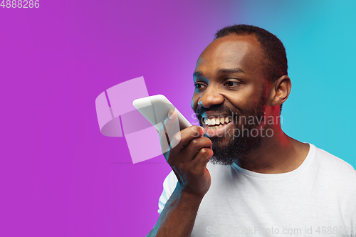 Image of African-american young man\'s portrait on gradient studio background in neon