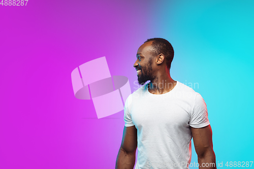 Image of African-american young man\'s portrait on gradient studio background in neon