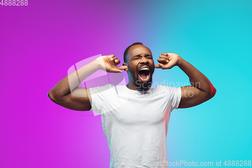 Image of African-american young man\'s portrait on gradient studio background in neon