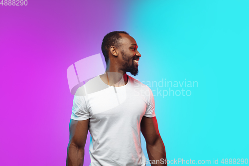 Image of African-american young man\'s portrait on gradient studio background in neon