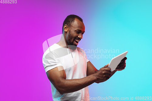Image of African-american young man\'s portrait on gradient studio background in neon