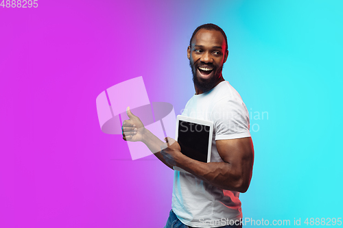 Image of African-american young man\'s portrait on gradient studio background in neon