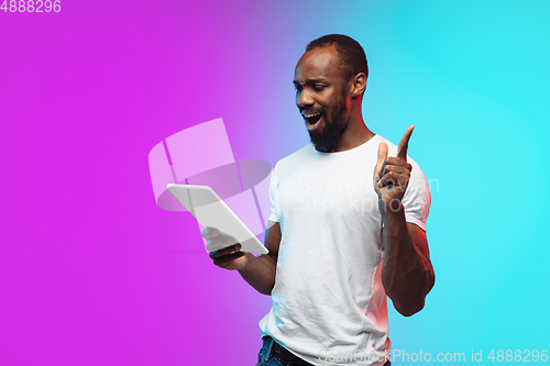 Image of African-american young man\'s portrait on gradient studio background in neon