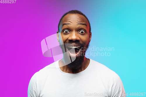 Image of African-american young man\'s portrait on gradient studio background in neon, close up