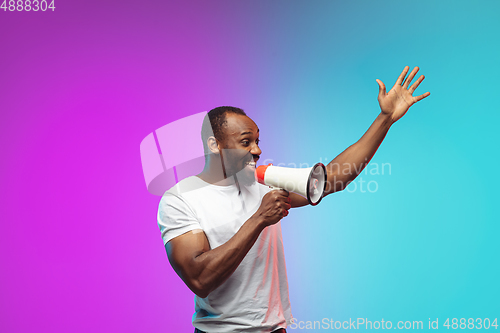 Image of African-american young man\'s portrait on gradient studio background in neon
