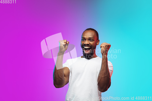Image of African-american young man\'s portrait on gradient studio background in neon