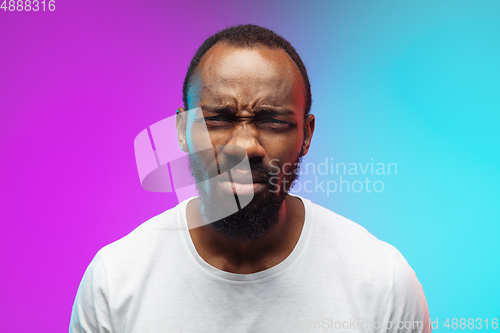 Image of African-american young man\'s portrait on gradient studio background in neon, close up
