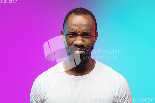 Image of African-american young man\'s portrait on gradient studio background in neon, close up