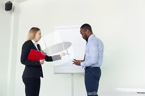 Image of Young businessman working with colleague using flipchart, copyspace