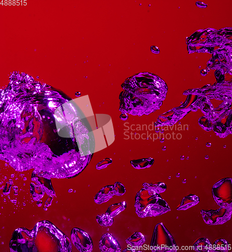 Image of Close up view of the cold and fresh cola with bright bubbles in neon light