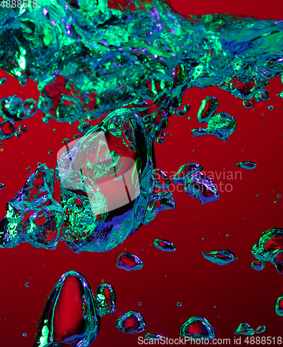 Image of Close up view of the cold and fresh cola with bright bubbles in neon light